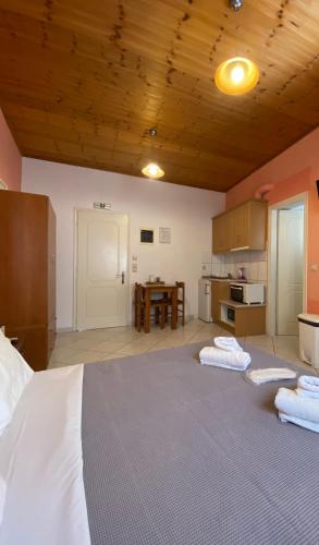 a large bedroom with two beds and a kitchen at Albatros rooms in Vathi