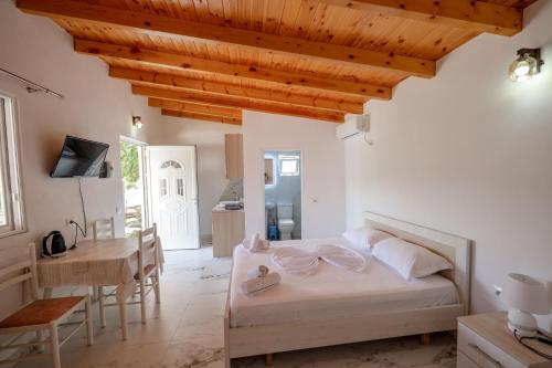 a bedroom with a bed and a table and a kitchen at Nino's rooms in Ksamil