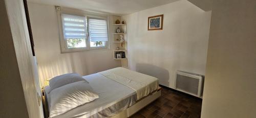a small bedroom with a bed and a window at chez Henri-Ange in Saint-Raphaël