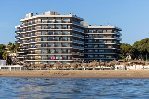 a building on the beach with a bunch of umbrellas at Golden Donaire Beach 4 Sup in La Pineda