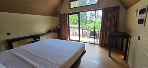 a bedroom with a bed and a window with a balcony at Riviera Resort in Batticaloa