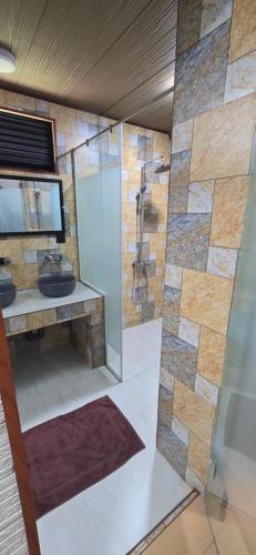 a bathroom with a glass shower and a sink at Riviera Resort in Batticaloa