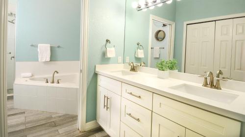 a bathroom with two sinks and a tub and a mirror at 802 Mariners Club in Key Largo