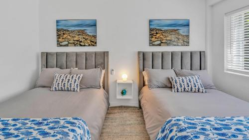 a bedroom with two beds and a table with a lamp at 812 Mariners Club in Key Largo