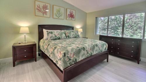 a bedroom with a bed and two dressers and a window at 808 Mariners Club in Key Largo