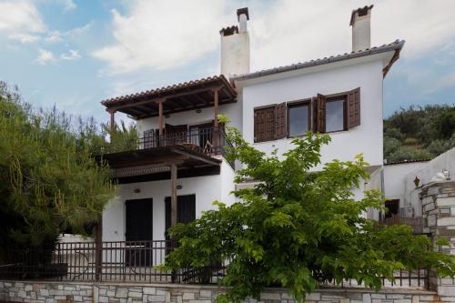 a white house with a balcony at Thalia- 2 Bedroom Beachfront Apartment! in Lefokastro