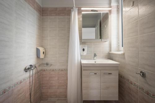 a bathroom with a sink and a shower with a mirror at Hotel Caretta Beach in Gerani
