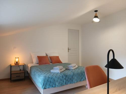 a bedroom with a bed with towels on it at La maisonnette in Saint-Georges-de-Luzençon