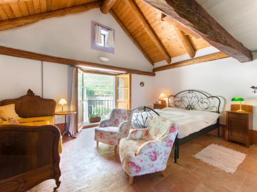 a bedroom with a bed and two chairs at Locanda L'Amorosa in Sementina