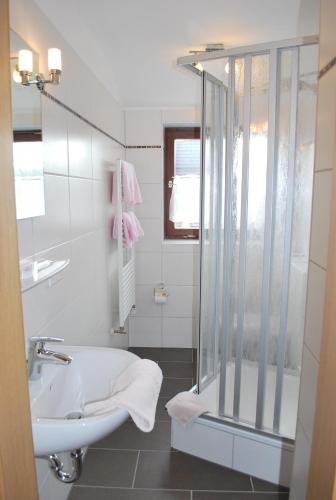uma casa de banho branca com um lavatório e um chuveiro em Gasthof Zur Linde em Diemelsee
