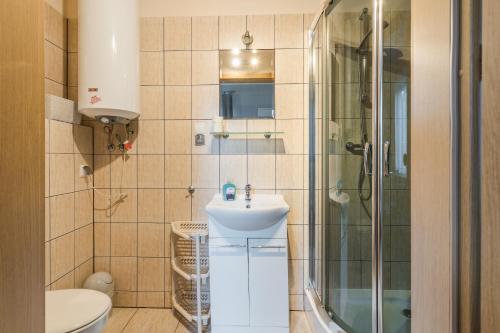 a bathroom with a sink and a shower at Apartamenty Zefir in Rowy