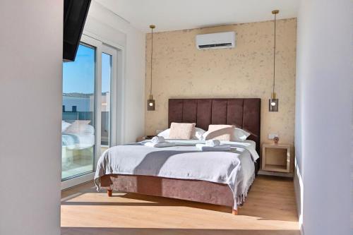a bedroom with a large bed and a large window at Timm - Luxury Villas in Vodice