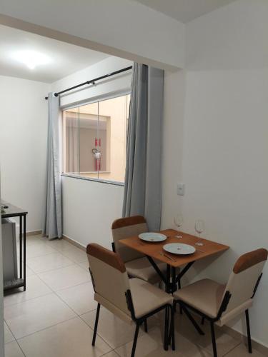 a dining room with a wooden table and chairs at Próximo a UFV 950m, prédio muito tranquilo in Viçosa