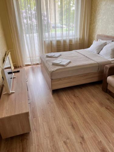 a bedroom with a bed and a wooden floor at Prisma Apartment in Tallinn