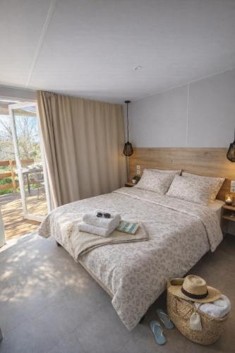 a bedroom with a large bed with towels on it at Camping Le Dolium in Laudun