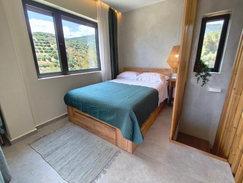 a bedroom with a bed in a room with windows at my suite home in Heraklio