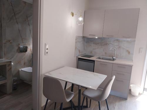 a kitchen with a table and chairs and a sink at Studios Rania in Skala Potamias