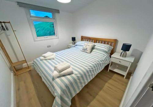 a bedroom with a bed with two towels on it at Elmrise View in Llanstephan