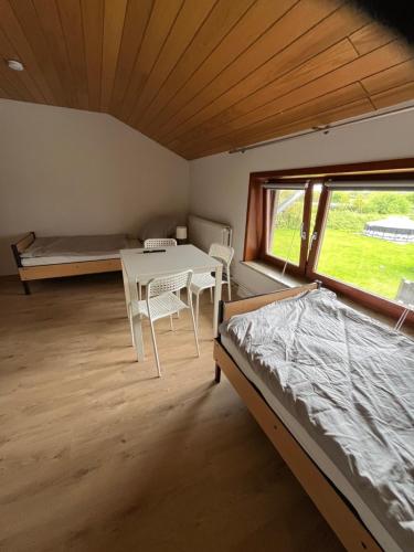 a bedroom with a table and a bed and a window at Helles 3 Bett Zimmer in Jerrishoe