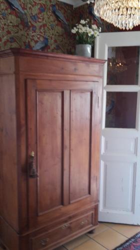 a large wooden cabinet in a room with a wall at Älgbergets Bed & Breakfast in Ucklum