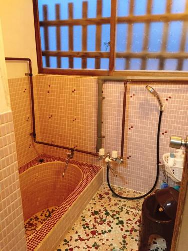 a bathroom with a tub and a toilet and a window at MEGANE HOUSE First floor All private in Rankoshi