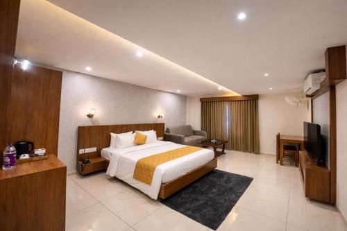 a hotel room with a bed and a television at Heaven Suite in Kalpetta