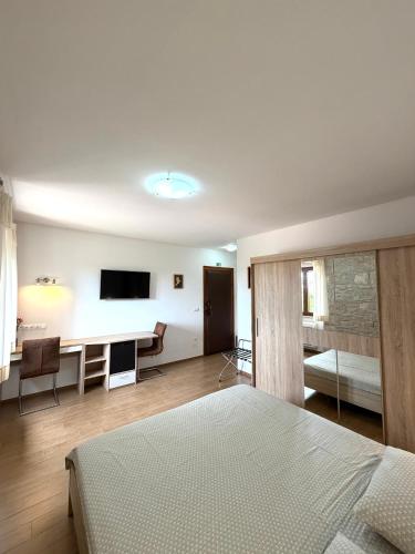 a bedroom with a bed and a desk and a television at Tea Rooms II in Bale