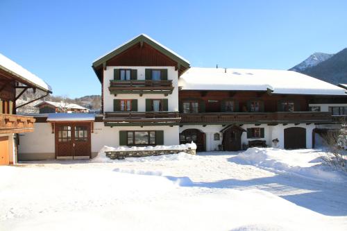 a house with snow on the ground in front of it at Ferienwohnungen Gastager in Ruhpolding