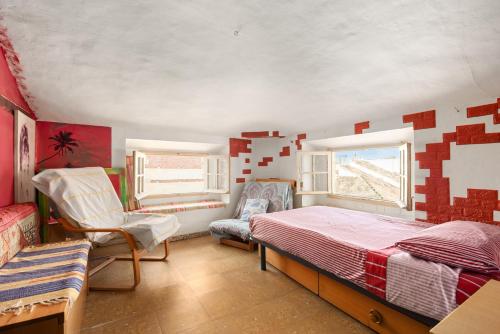 a bedroom with a bed and a chair in it at Buhardilla en centro histórico in Málaga