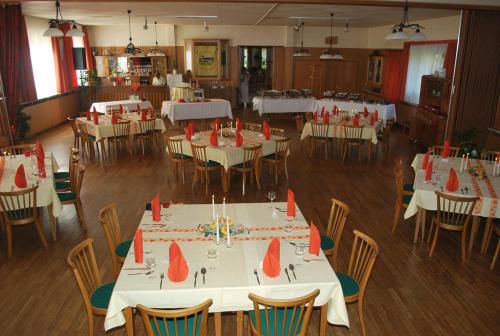 uma sala de jantar com mesas e cadeiras com guardanapos vermelhos em Gasthof Zur Linde em Diemelsee