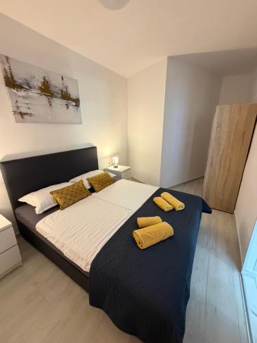 a bedroom with a large bed with two yellow pillows at Apartments Lory in Rabac