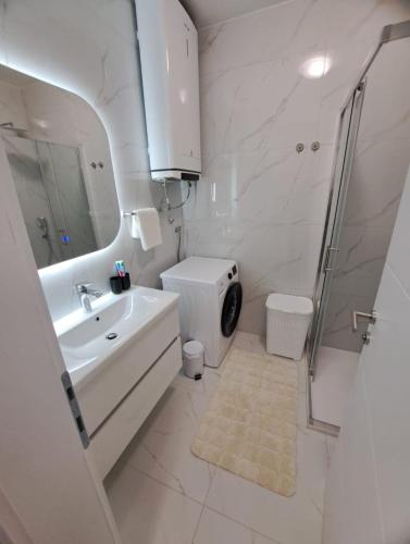 a white bathroom with a sink and a toilet at Apartman Sunce in Posušje