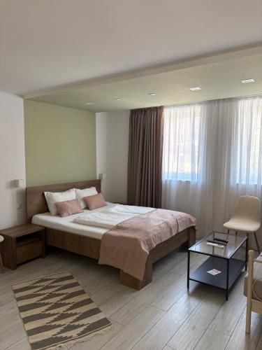a bedroom with a large bed and a chair at Villa Aba apartments in Sarajevo