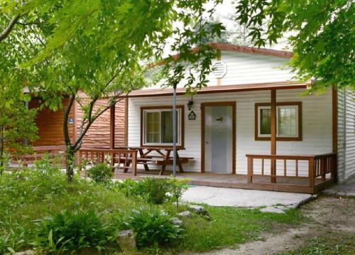 a house with a porch with benches on it at Pocheon Haneulbat Pension in Pocheon