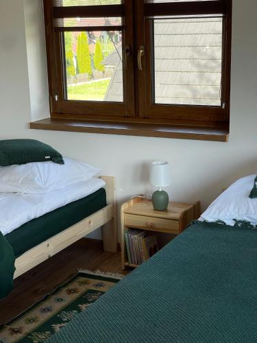 a bedroom with two beds and a window at Na Młace Apartament z widokiem in Witów