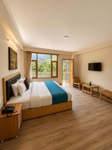 a bedroom with a large bed and a large window at Crest Manali River View in Manāli