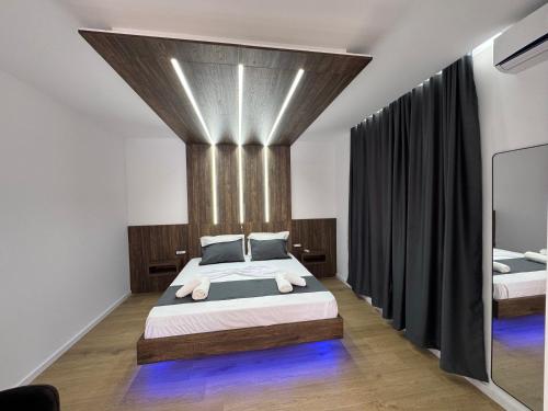 a bedroom with a king sized bed and black curtains at Infinity Suites Pushi in Ksamil