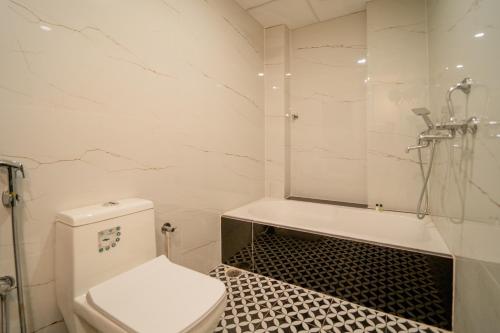 a white bathroom with a toilet and a shower at palm hotel mansarovar in Jaipur