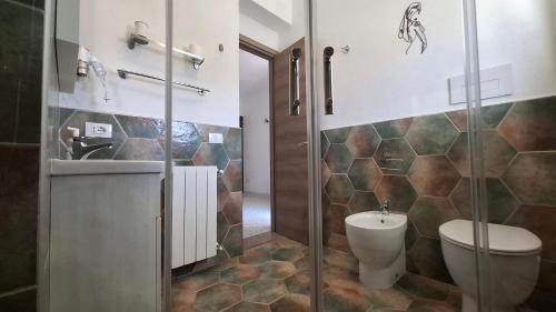 a bathroom with a shower and a toilet and a sink at Phiniscollis B&B in La Caletta