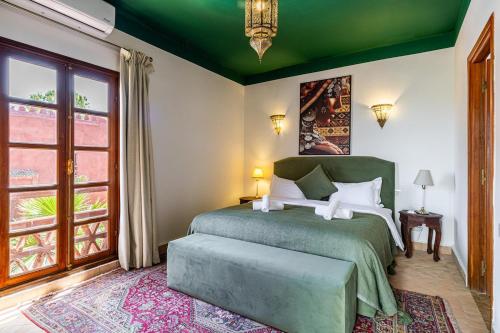 a bedroom with a green bed and a window at Traditional Villa Dar Izza - 4 suite with breakfast in Douar Soukkane