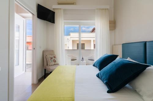 a bedroom with a bed with blue and green pillows at Baia Di Torre Squillace in Sant'Isidoro