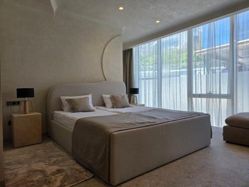 a bedroom with a large bed and a large window at Blu Mare Residense in Odesa