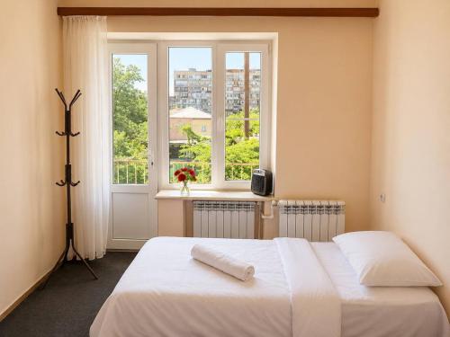 a bedroom with a white bed and a window at Sunshine Boutique Hostel in Yerevan