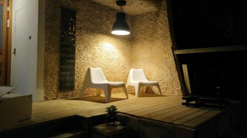 two white chairs sitting on a wooden floor in a room at Quiet Garden in Rishon LeẔiyyon