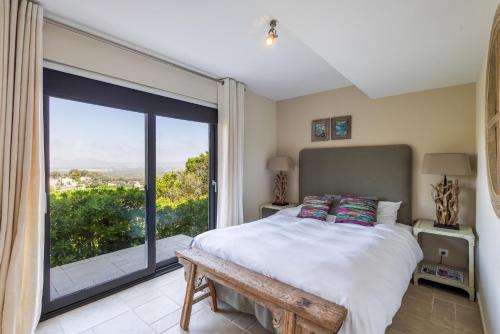 a bedroom with a bed and a large window at Sa Punta 99 F2 in Begur