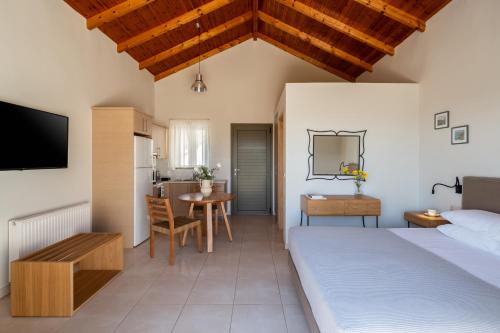 a bedroom with two beds and a table and a kitchen at Anassia Villas in Nafplio