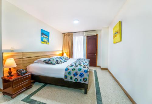 a hotel room with a bed and a nightstand and a bed sidx sidx sidx at Hotel San Pedro del Fuerte in Medellín