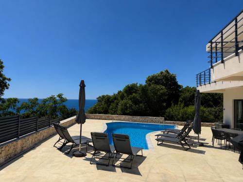 a swimming pool with chairs and umbrellas next to a building at Villa LiRa Star Bar Montenegro - Exclusive Adriatic Villa with Private Pool Starry Sky Lounge in Stari Ulcinj