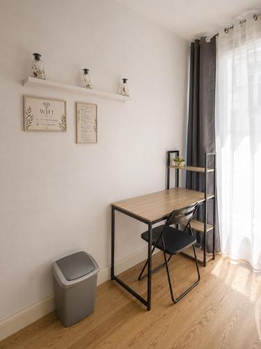 a table and a trash can in a room at Chambre moderne au Petit Bayonne chez particulier in Bayonne