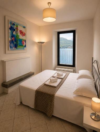 a bedroom with a large bed and a window at Diamante sull'acqua in Sale Marasino